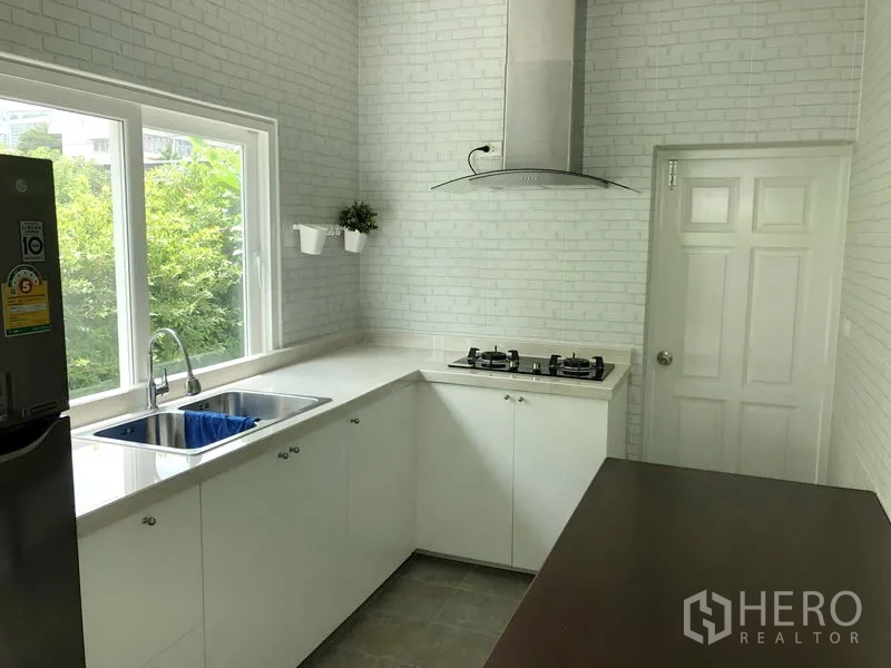 独立式住宅 出租或出售在Huai Khwang, Bangkok - 明亮的L形中式厨房，配燃气灶、抽油烟机与水槽窗景