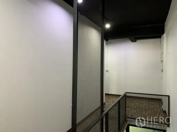店屋 出租在Watthana, Bangkok - 夹层走廊，黑色网格护栏与筒灯照明。