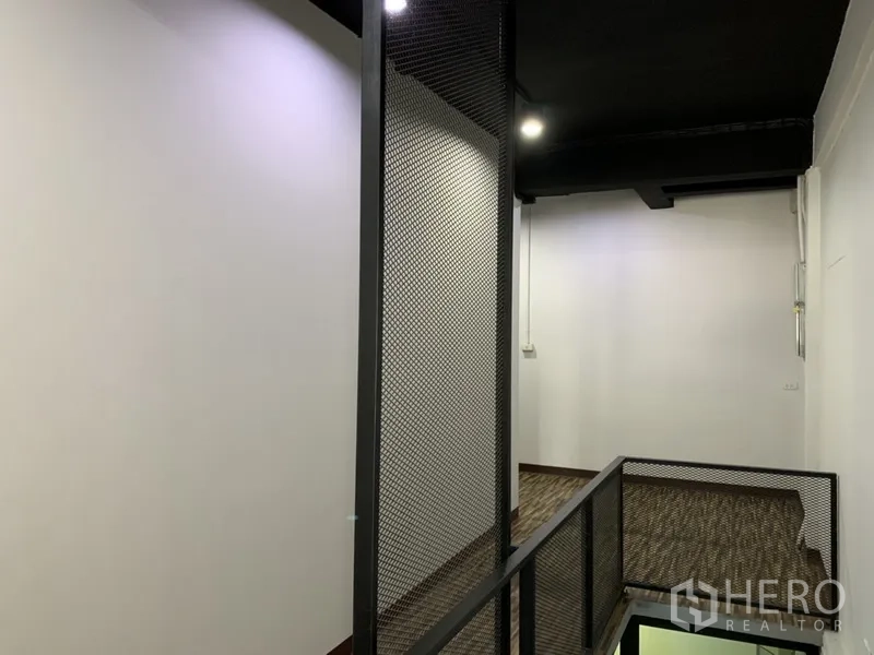 店屋 出租在Watthana, Bangkok - 夹层走廊，黑色网格护栏与筒灯照明。