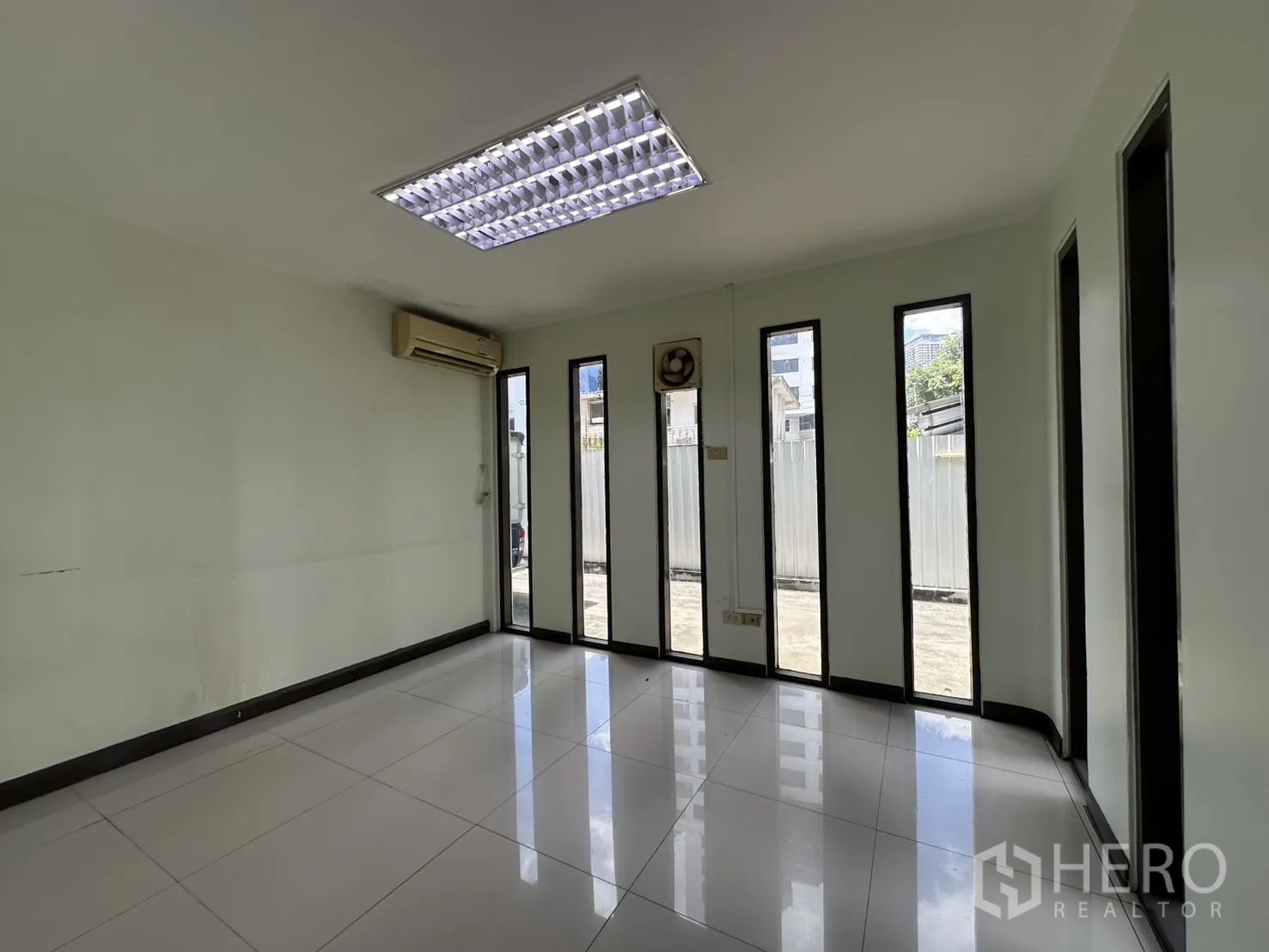 Retail Space for rent in Watthana, Bangkok - Bright room with narrow floor-to-ceiling windows and wall-mounted A/C.