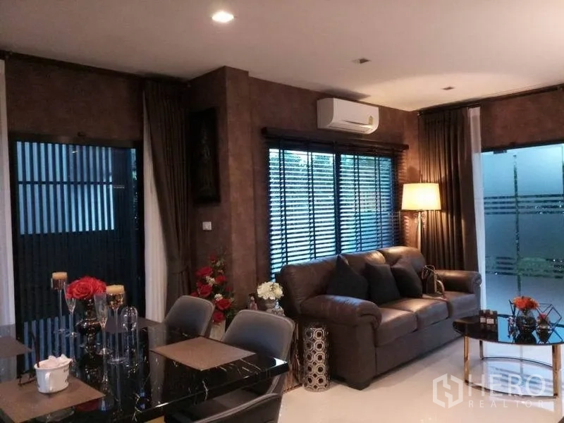 Detached House for sale in Nonthaburi - Open-plan living and dining room with sofa, air-conditioning and floor lamp.