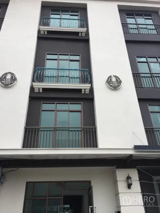 Home Office for rent in Wang Thonglang, Bangkok - Multi-storey home office facade with large windows and small balconies in a black-and-white scheme.