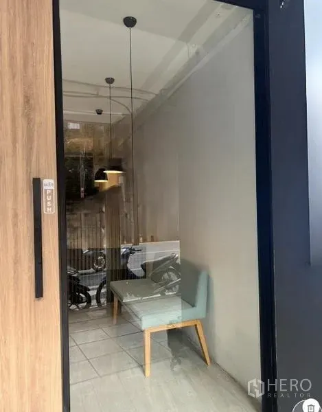 Retail Space for rent in Watthana, Bangkok - Close view of the glass entrance showing a bench seat and pendant lighting inside the shop.