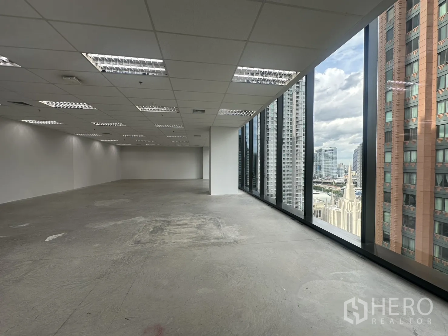 办公室 for rent in Ratchathewi, Bangkok - 大面积未配家具的办公室，吊顶灯具与整面落地玻璃立面。