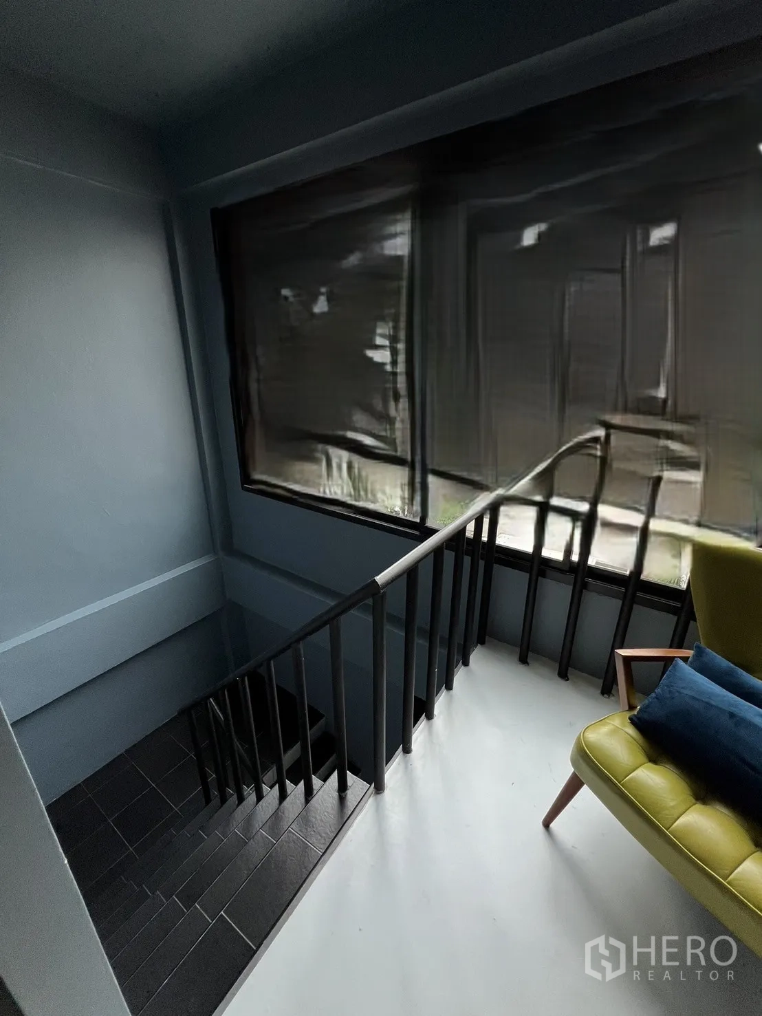 Shophouse for rent or sale in Watthana, Bangkok - Landing area with large window and lounge chair beside the staircase.