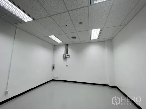 Retail Space for rent in Watthana, Bangkok - Bright white retail unit with acoustic tile ceiling, fluorescent lighting and grey epoxy floor.
