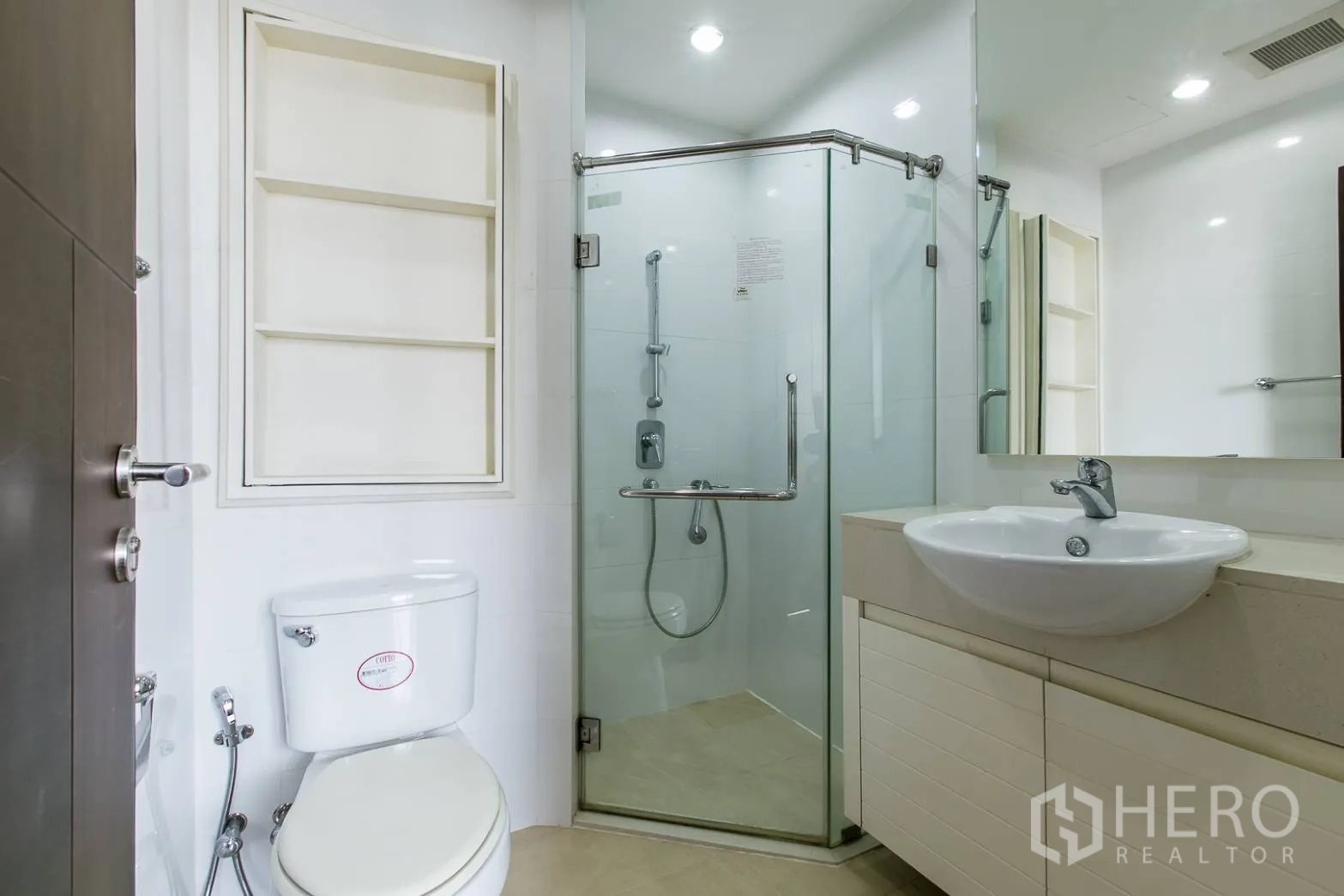 Condominium for rent or sale in Khlong Toei, Bangkok - Modern bathroom with glass shower enclosure, vanity and toilet.
