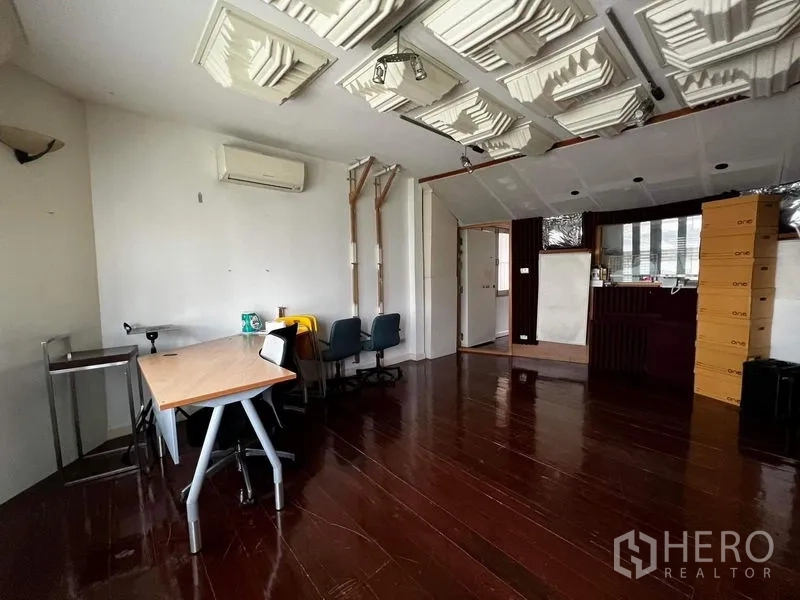 Townhouse for rent - Multipurpose room with acoustic ceiling panels and desks.