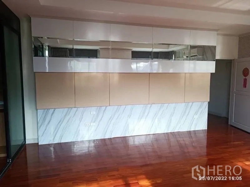 Detached House for sale in Prawet, Bangkok - Feature wall with glossy cabinets and marble cladding in an upstairs room.