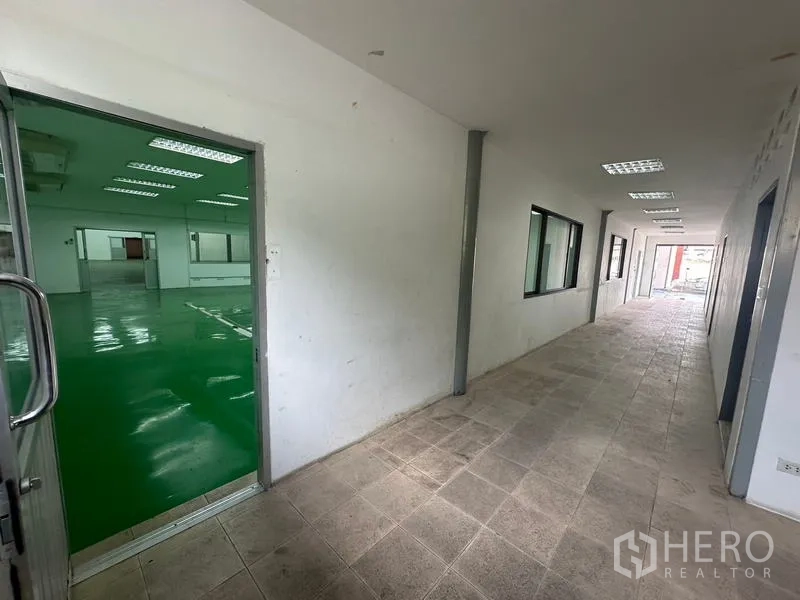 Warehouse for rent in Suan Luang, Bangkok - Internal corridor with view into a climate-controlled green-floor room.