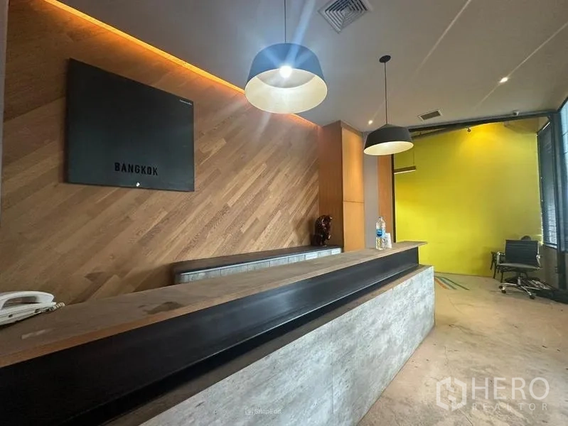 Office Space for rent - Modern reception with concrete counter, wood feature wall and pendant lights.