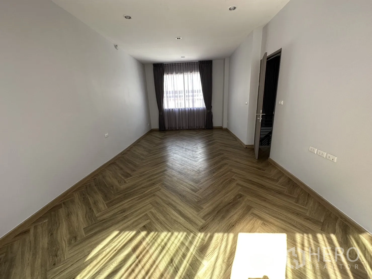 Home Office for rent or sale in Suan Luang, Bangkok - Sunlit bedroom with herringbone flooring and a wide window ready for fit-out.