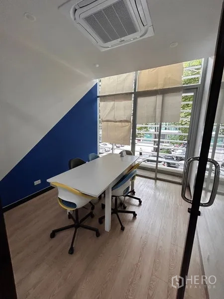 Office Space for rent in Khlong Toei, Bangkok - Compact meeting room with glass door, table and chairs, wood floors and tall windows with blinds.