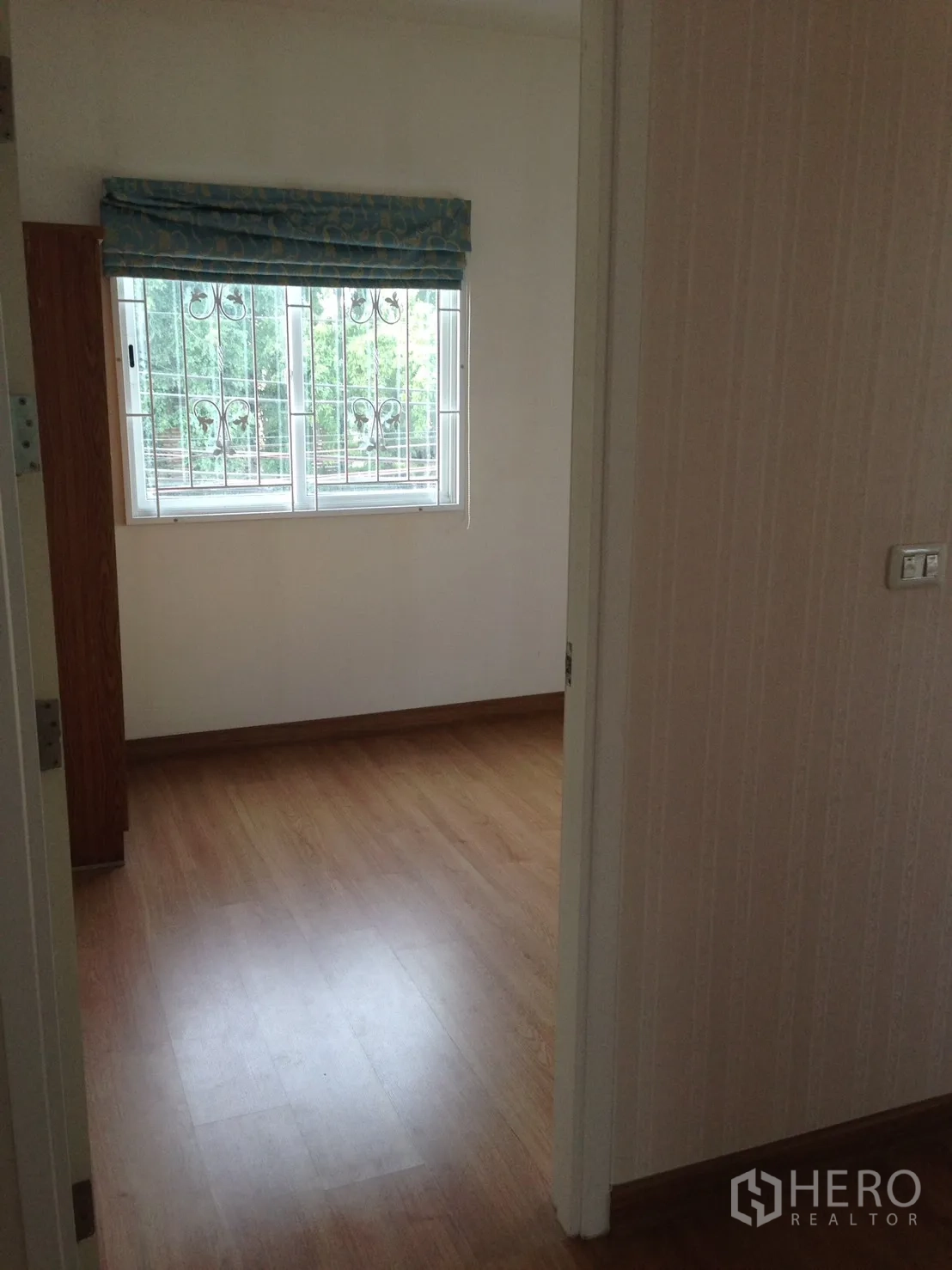 Detached House for rent in Suan Luang, Bangkok - Bedroom with wood-style flooring and a window fitted with security grilles