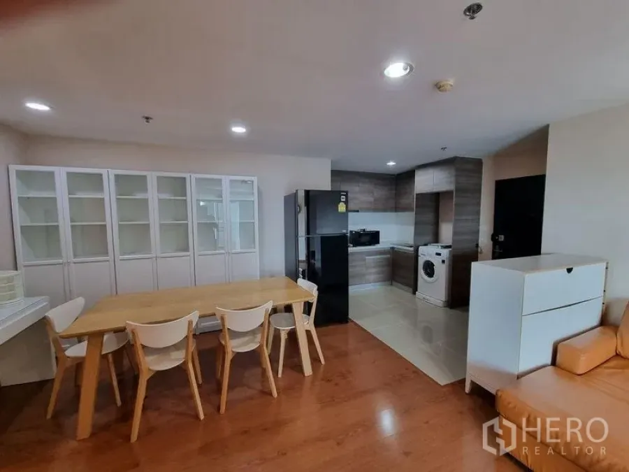 Condominium for rent in Huai Khwang, Bangkok - Dining space with white display cabinets beside the kitchen area.