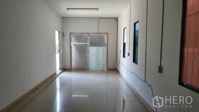 Warehouse for rent in Pathum Thani - Office corridor with windows to the warehouse and a sliding glass entrance.