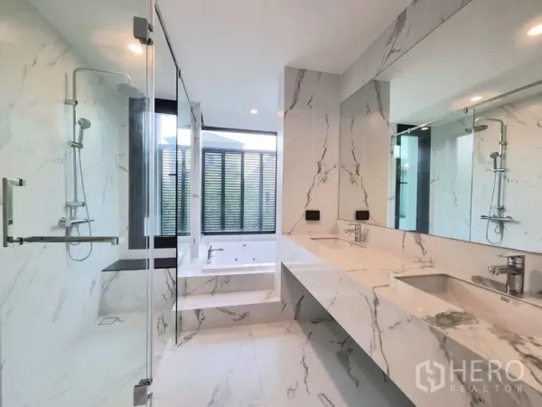 Detached House for rent - Luxury marble bathroom featuring double vanity, large mirrors and a glass-enclosed rain shower.