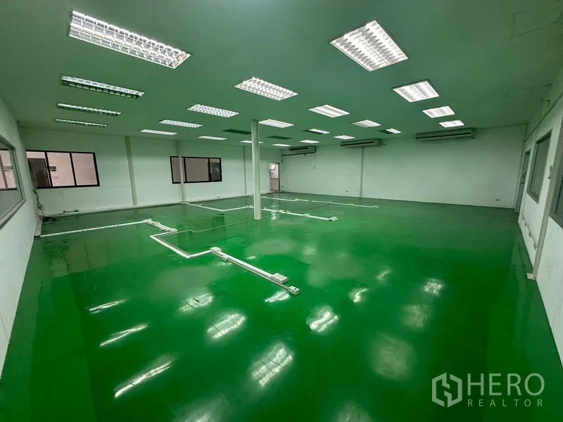 Warehouse for rent in Suan Luang, Bangkok - Production room with green epoxy floor and visible utility conduits.