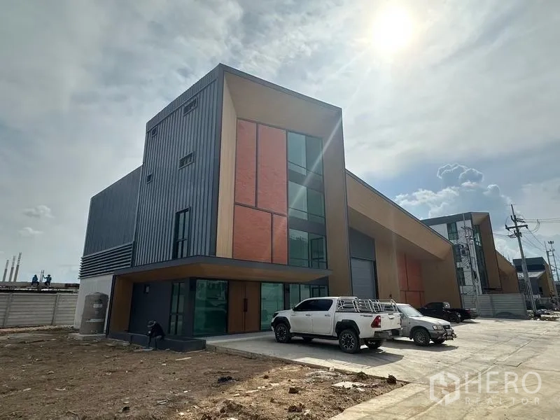 Warehouse for sale in Lam Luk Ka, Pathum Thani - Side exterior showing three-storey office block, warehouse bay and ample parking apron.