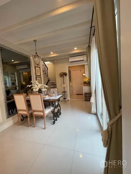 Detached House for rent or sale in Pathum Thani - Dining area by sliding glass doors connected to the kitchen and a mirrored wall.