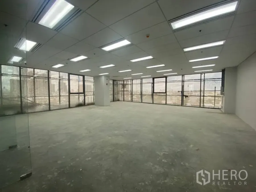 Office Space for rent - Bright empty office floor with drop ceiling lights and panoramic windows.