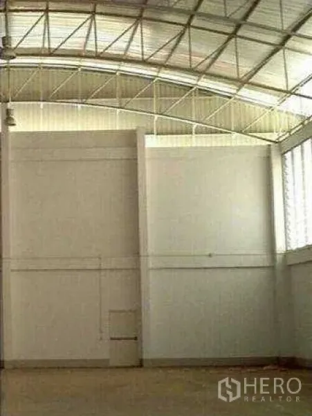 Factory for rent in Krathum Baen, Samut Sakhon - Tall warehouse wall with daylight glass blocks and louvered windows providing natural light and airflow.