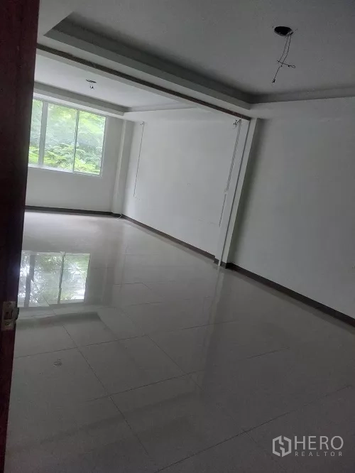 Shophouse for rent in Bang Rak, Bangkok - Bright corner room with tray ceiling and a large window.