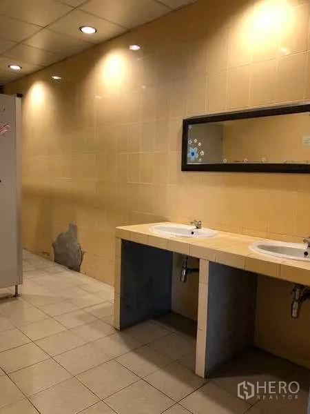 Warehouse for rent in Bang Phli, Samut Prakan - Staff restroom with twin sinks, tiled walls and recessed ceiling lights.