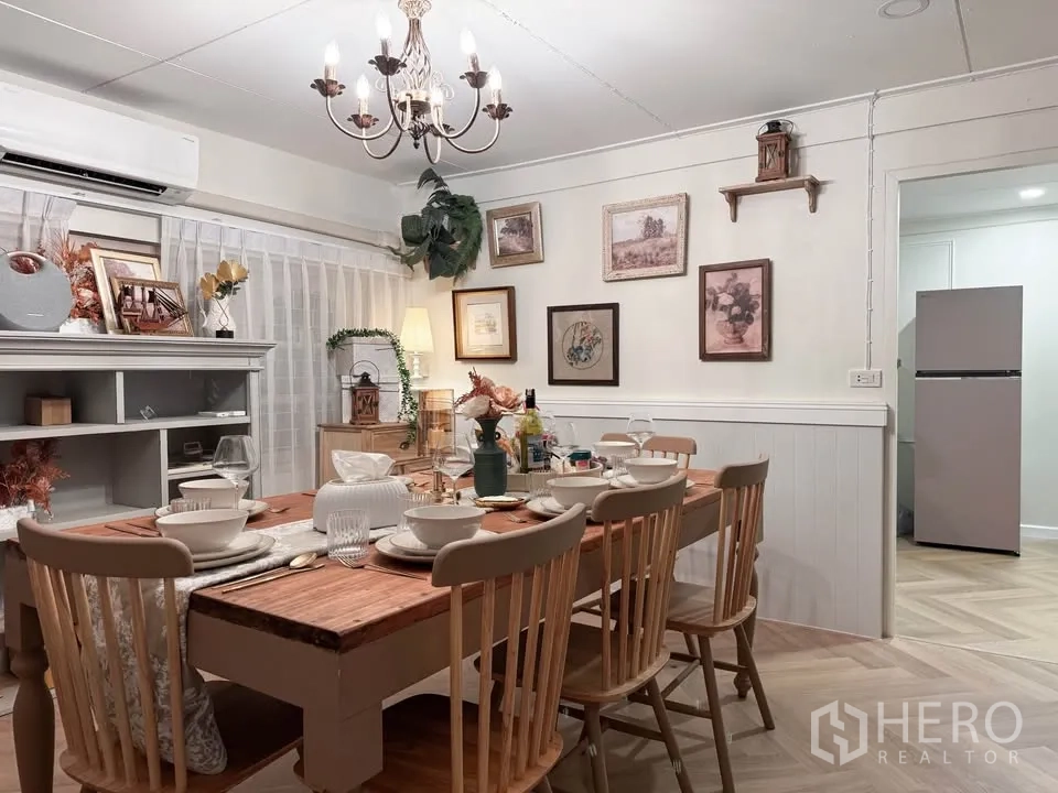 Detached House for rent in Huai Khwang, Bangkok - Dining room with chandelier, wooden table set and built-in shelving.