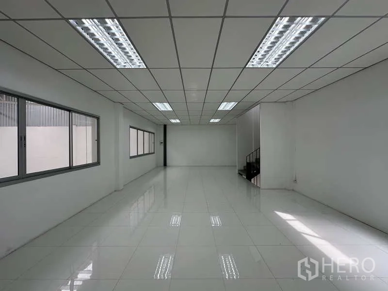 Factory for rent in Khlong Luang, Pathum Thani - Open-plan office with long window line and fluorescent lighting.