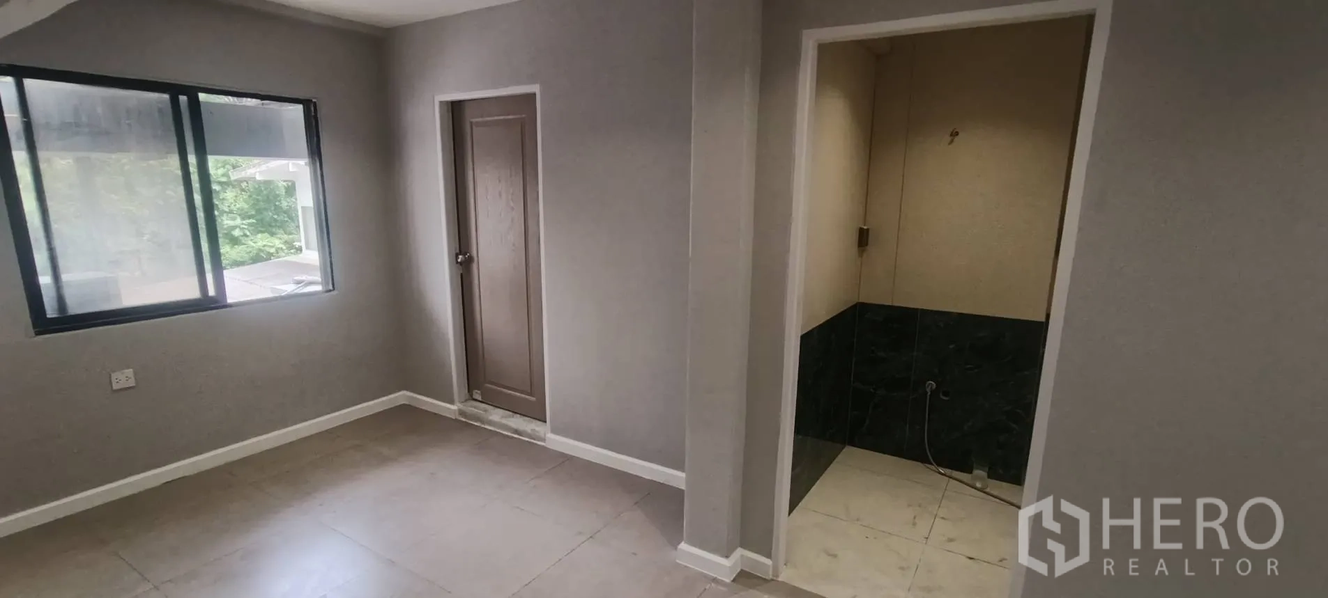 Office Space for rent in Watthana, Bangkok - Small corner room with sliding window and doorways to service areas.