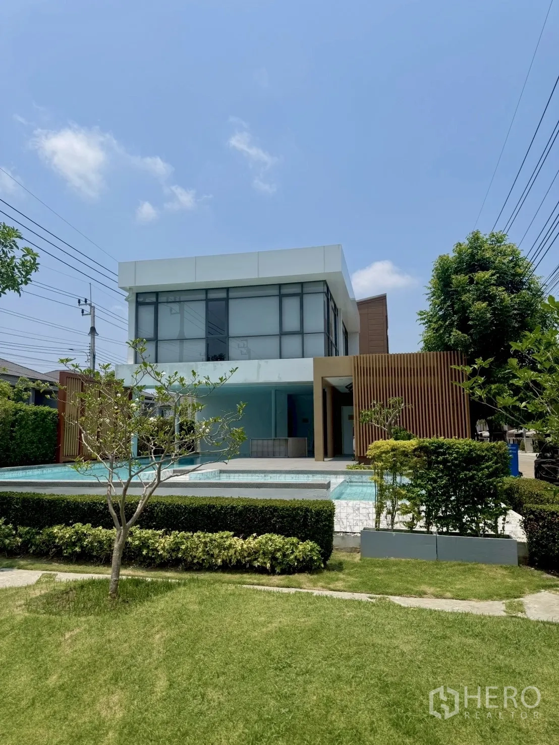 Townhouse for rent in Prawet, Bangkok - Community clubhouse with outdoor swimming pool and manicured lawn.