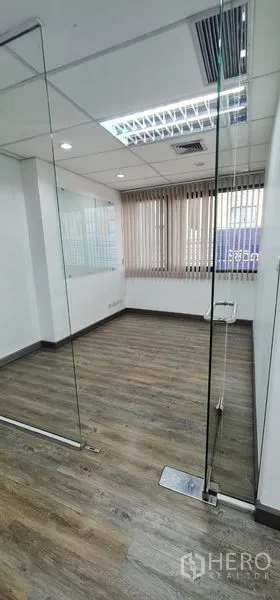 Office Space for rent in Watthana, Bangkok - Compact glass‑walled meeting room with wood‑look flooring and blinds.