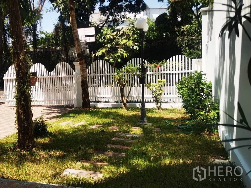 Detached House for rent in Mueang Samut Prakan, Samut Prakan - Sunny lawn with stepping stones, a vintage lamppost and a white picket fence.