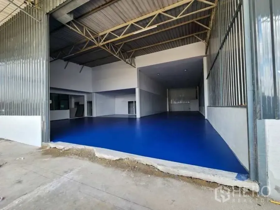 โรงงาน ให้เช่าในLam Luk Ka, Pathum Thani - อาคารโรงงานเพดานสูง พื้นอีพ็อกซี่สีน้ำเงิน โครงหลังคาเหล็ก และทางเข้าขนส่งกว้าง