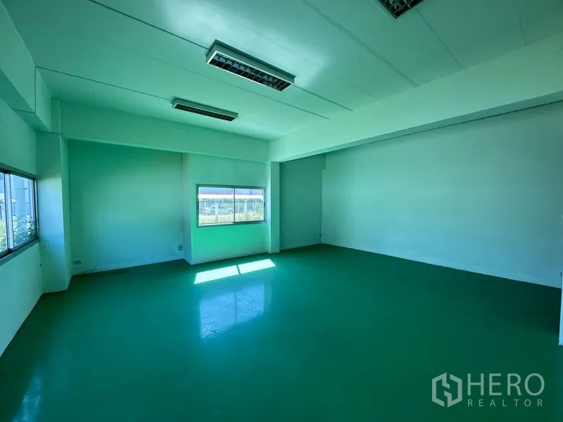 Factory for rent in Chon Buri - Bright office or QC room with green epoxy flooring and windows on two sides.