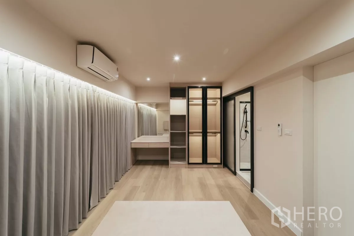 Townhouse for rent in Watthana, Bangkok - Bedroom with wardrobe, ensuite shower and light wood flooring.