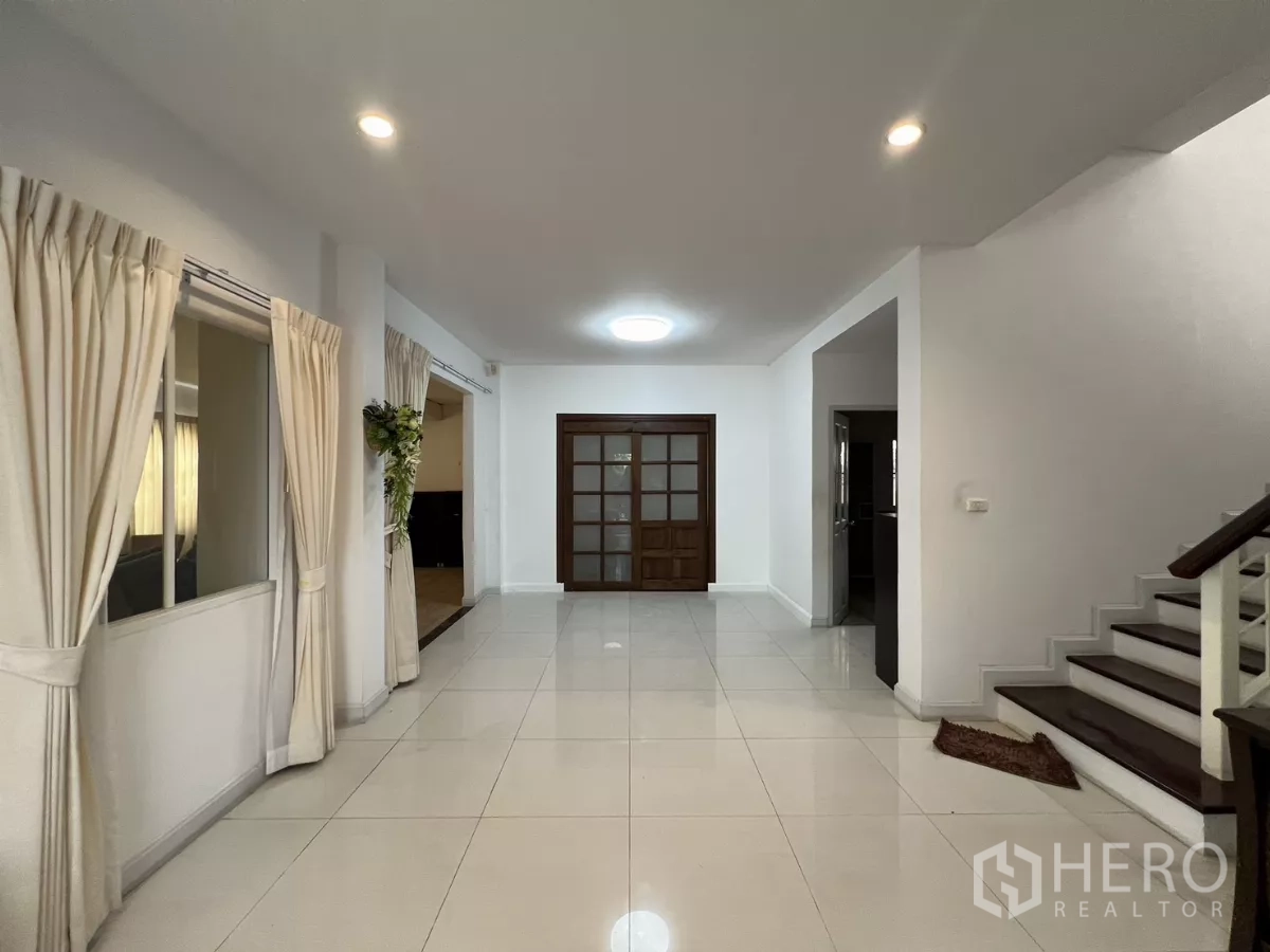 Detached House for rent in Bang Kapi, Bangkok - Wide foyer with staircase and wooden framed glass doors.