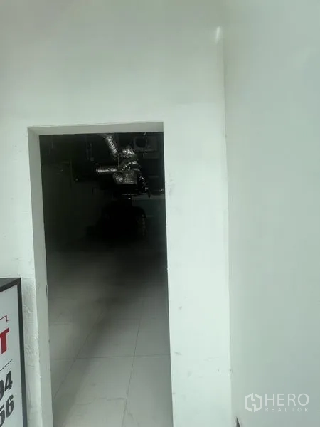 Retail Space for rent in Watthana, Bangkok - Secondary access doorway leading into the unfinished retail interior.