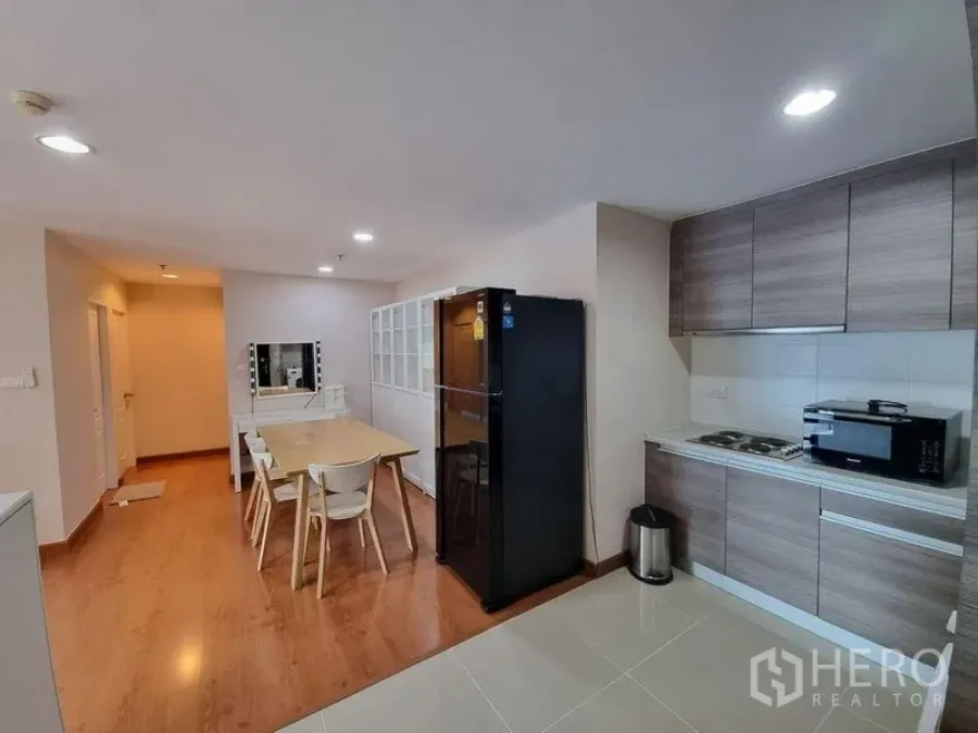 Condominium for rent in Huai Khwang, Bangkok - Open-plan kitchen and dining area with wood flooring and recessed lighting.