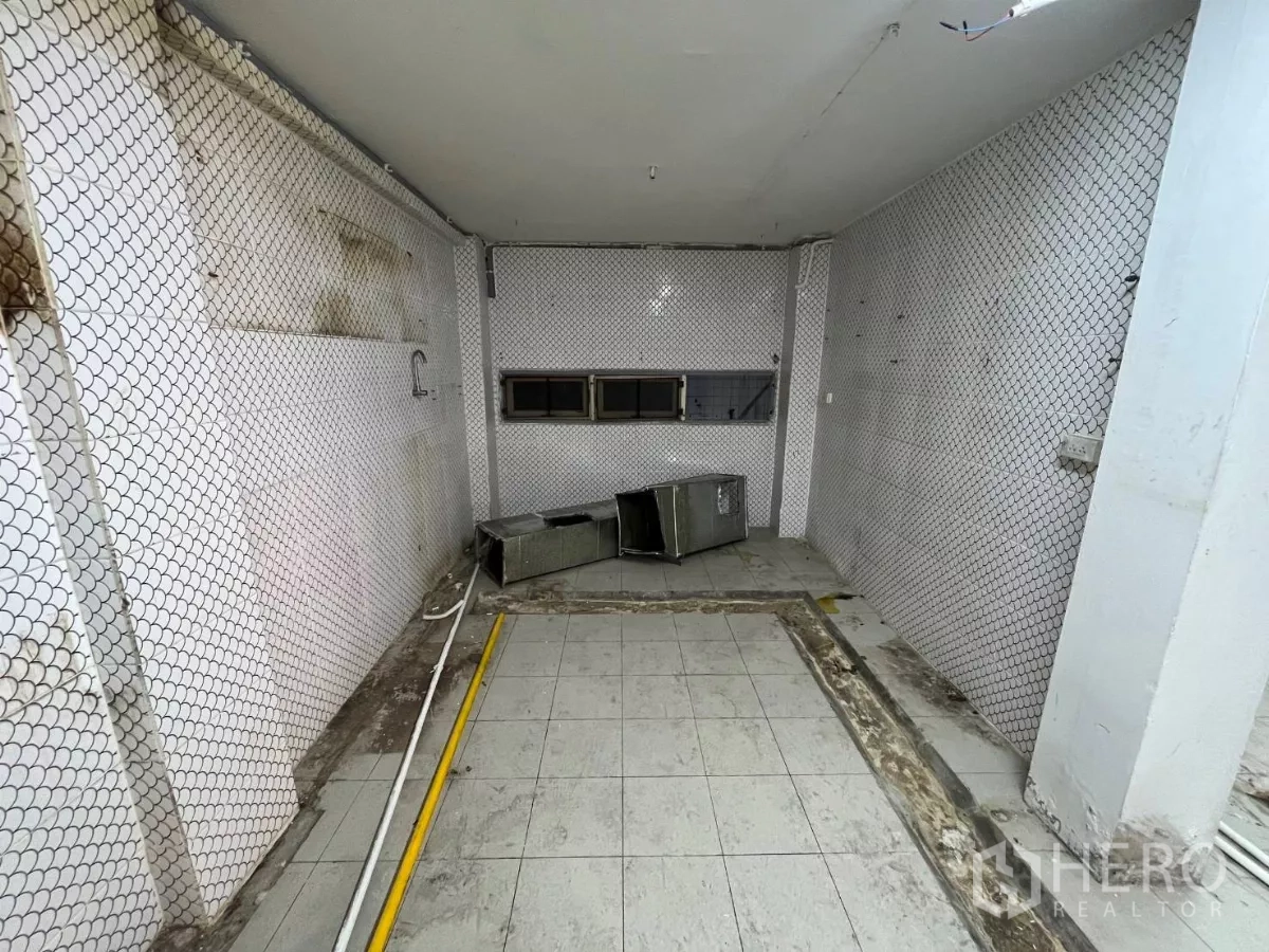 店屋 出租在Watthana, Bangkok - 一层瓷砖空间，金属网墙面与横向小窗，适合作为储物或服务区。