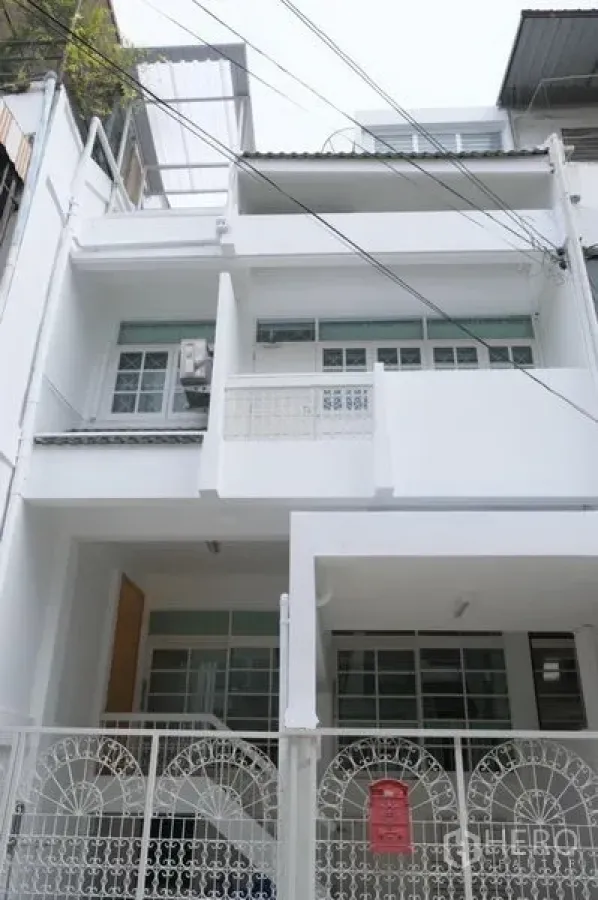 ทาวน์เฮาส์ ให้เช่าในKhlong Toei, Bangkok - ทาวน์เฮ้าส์ 3 ชั้นสีขาวพร้อมประตูรั้วและที่จอดรถหน้าอาคารในซอยเงียบสงบ