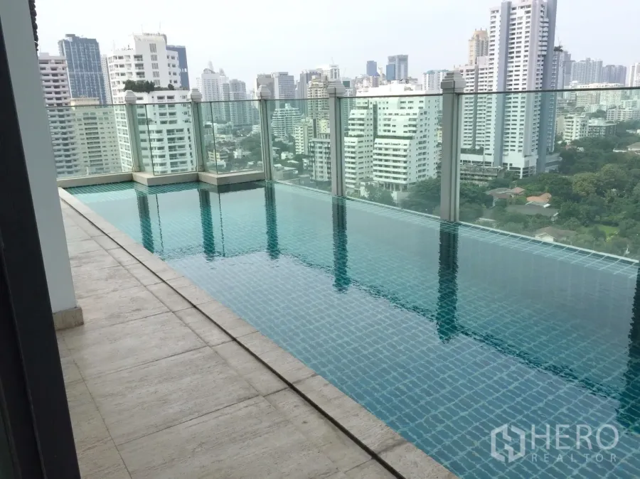 Condominium for rent in Watthana, Bangkok - High-rise condominium swimming pool with glass railing overlooking the Bangkok skyline.