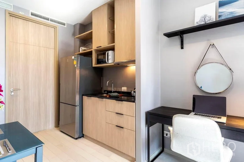 Condominium for rent in Pathum Wan, Bangkok - Close-up of pantry kitchen with fridge, microwave, open shelving and an adjacent work desk.