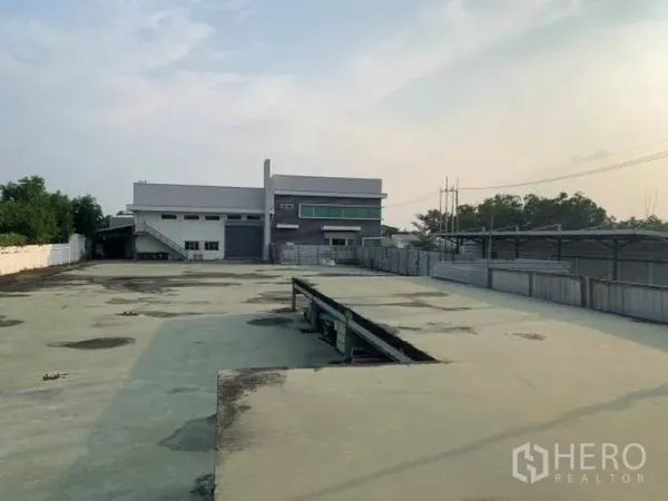 Factory for rent or sale in Wang Noi, Phra Nakhon Si Ayutthaya - Wide concrete yard leading to a modern factory building with offices.