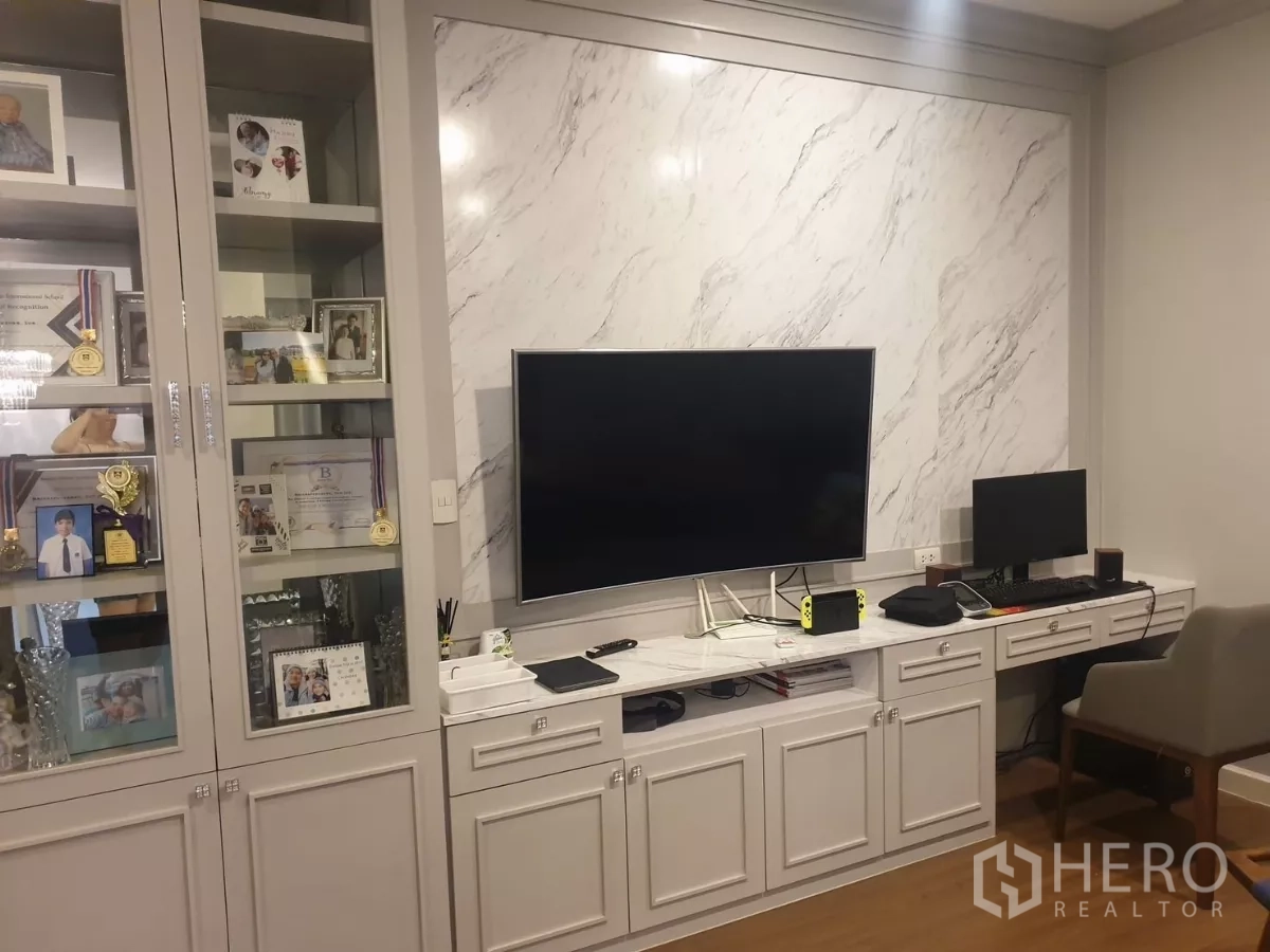 Detached House for rent or sale in Prawet, Bangkok - Built-in display shelves and TV unit with marble backdrop in multi-purpose room