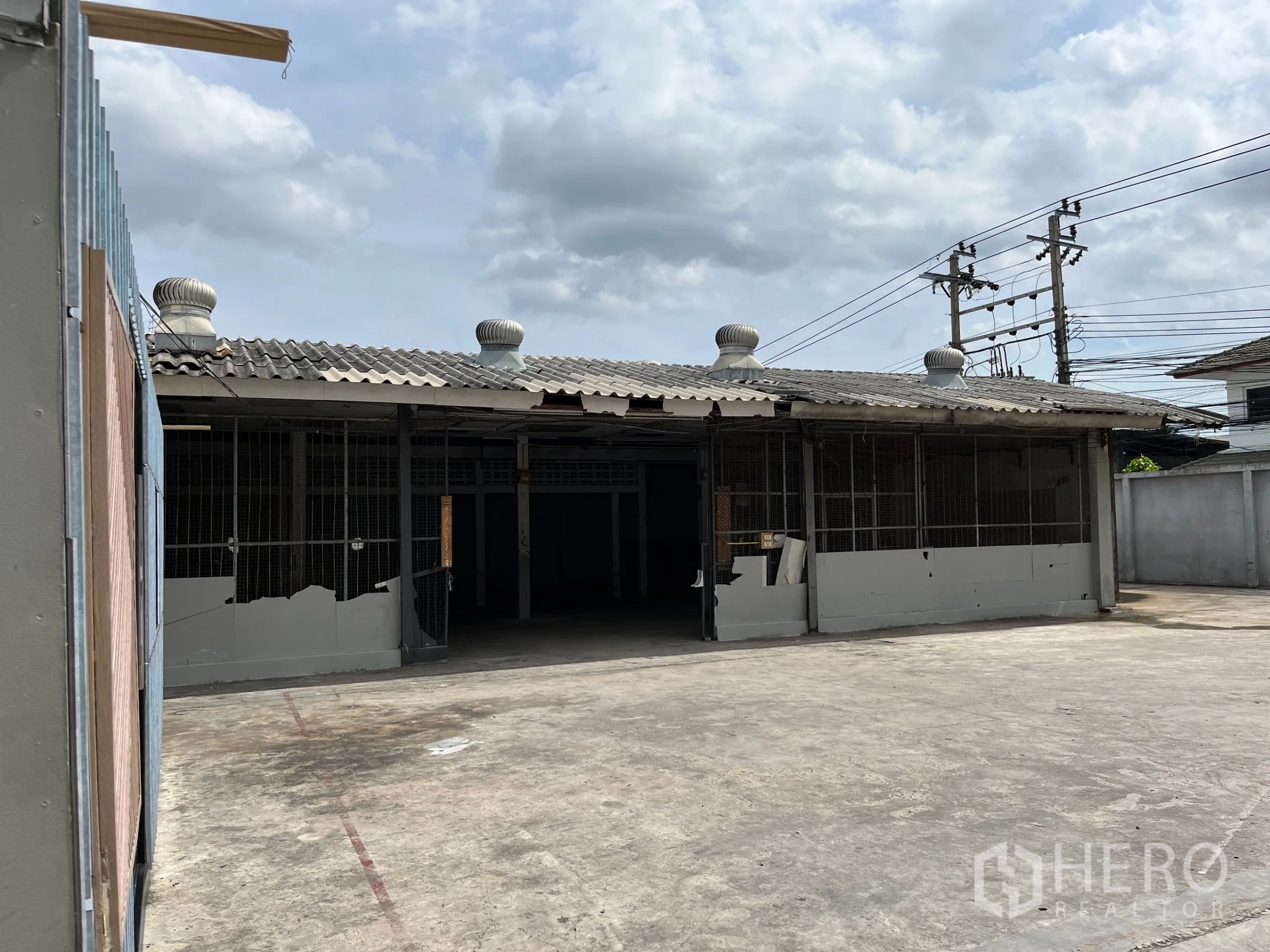 Warehouse for rent in Bangkok - Front elevation of the warehouse with sliding gates, roof ventilators and open forecourt.