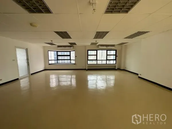 Office Space for rent in Pathum Wan, Bangkok - Open office with wide windows, city views, ceiling air conditioners and grid lighting.