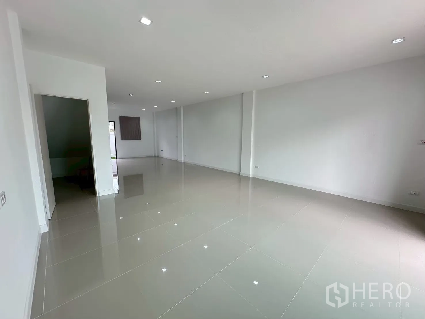Home Office for rent in Lat Phrao, Bangkok - Ground-floor open-plan space with high-gloss tiles and multiple downlights.