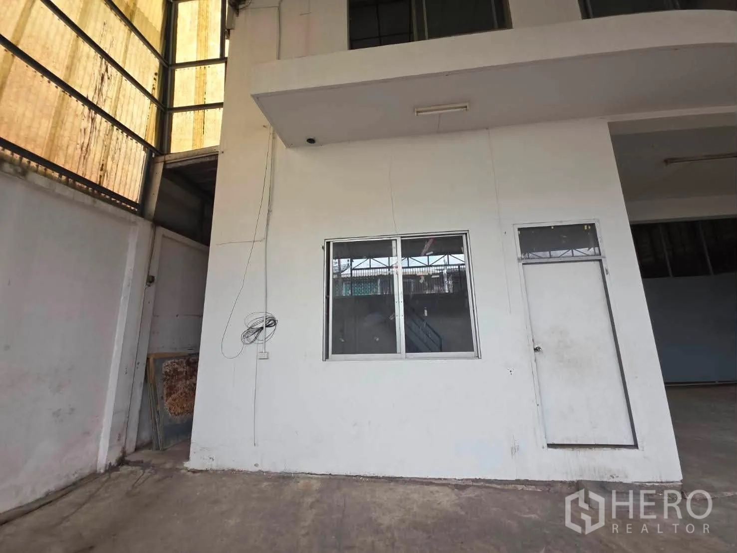 Warehouse for rent or sale in Phra Khanong, Bangkok - External view of internal office block with window and door inside the warehouse.